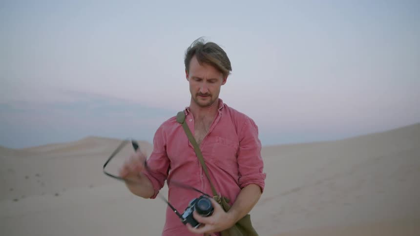 A man with a bag and camera and he is taking them off and taking pictures