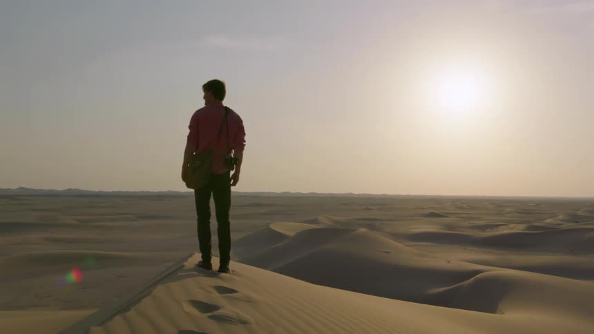Man walks through the desert on a sunny day