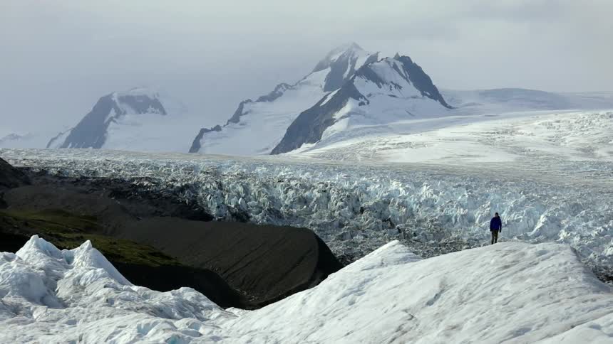 A man stands on an icy hill