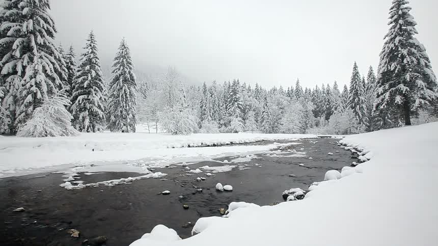 A creek flowing through a wintry landscape