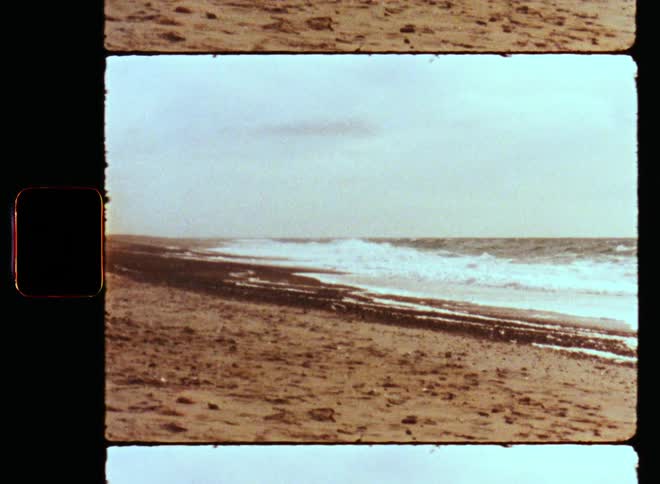 Ocean waves wash into a sandy beach during the day as the fresh coastal breeze or wind blows on a sunny day at the coast or sea