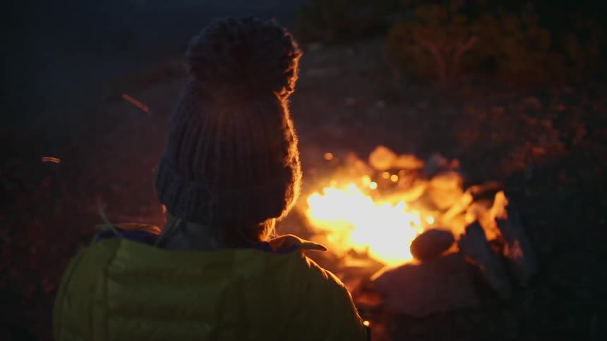 People sit around a fire at night