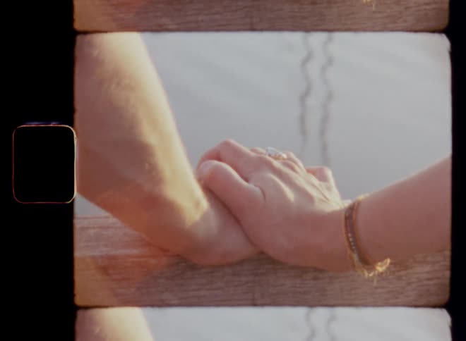 Vintage 8 mm close up of a young couple holding hands in love overlooking a body of water while starting a romance on a Valentine’s Day date