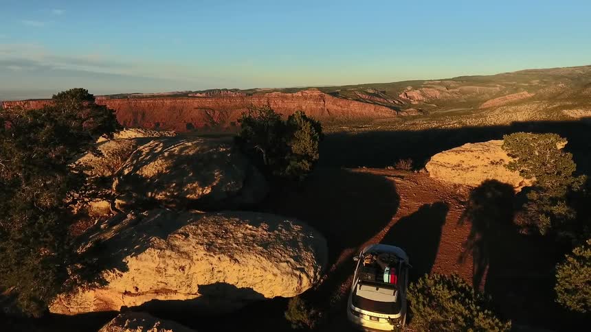 Vehicle riding through dirt between very large rocks