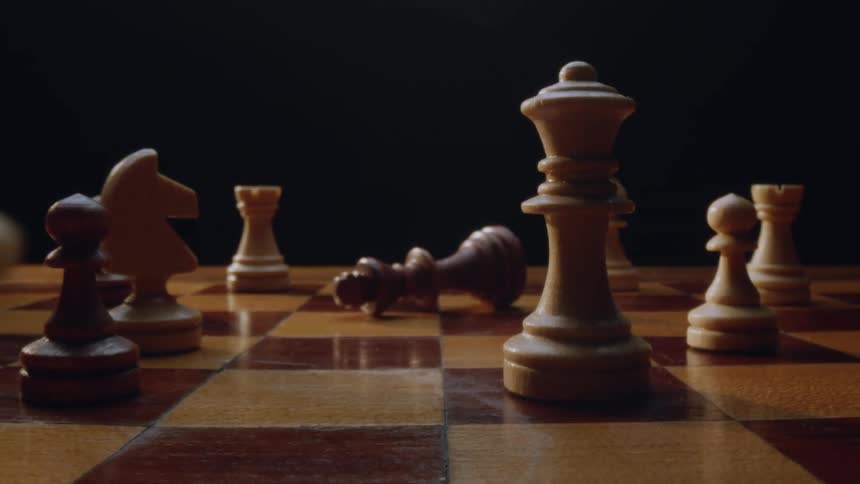 A fallen down chess amid other pieces on a chess board