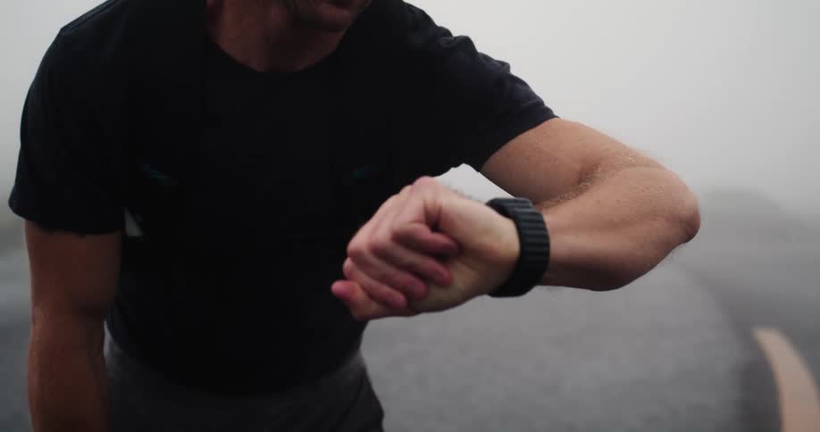 Man looks at his watch before jogging