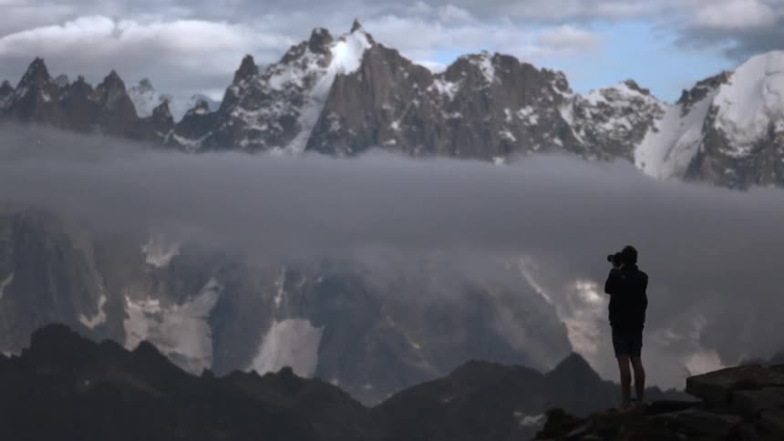 A person is on a mountain top taking photographs