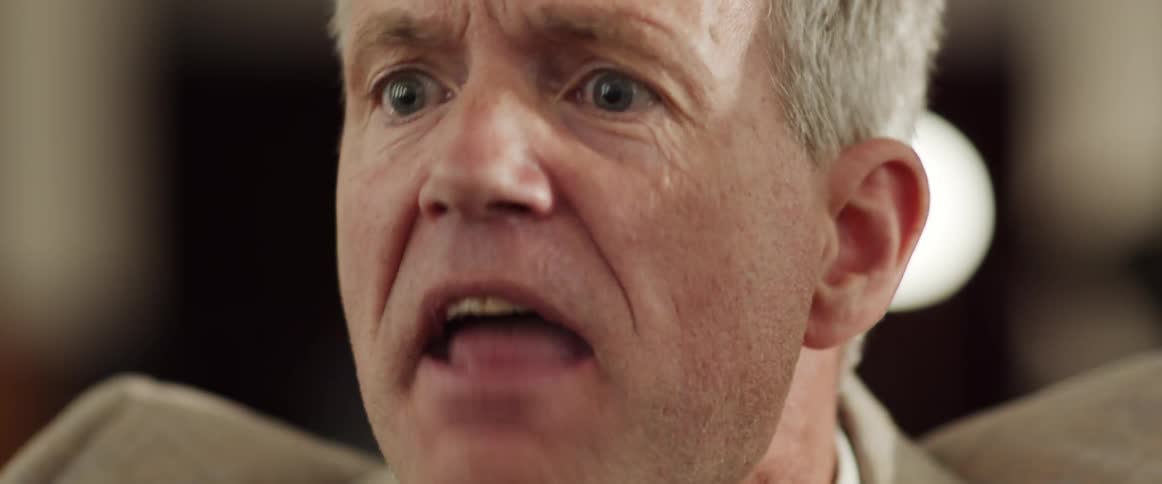 An angry man yelling indoors