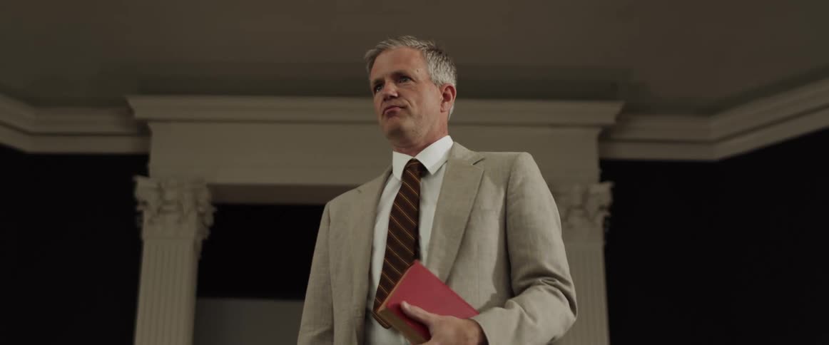 There is someone talking at church and holding a bible