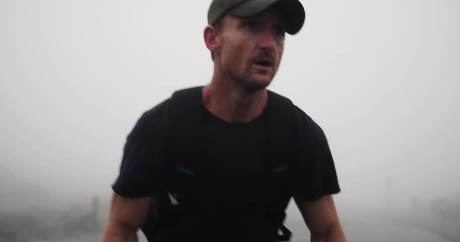 A man is getting ready to jog outdoors on tarmac