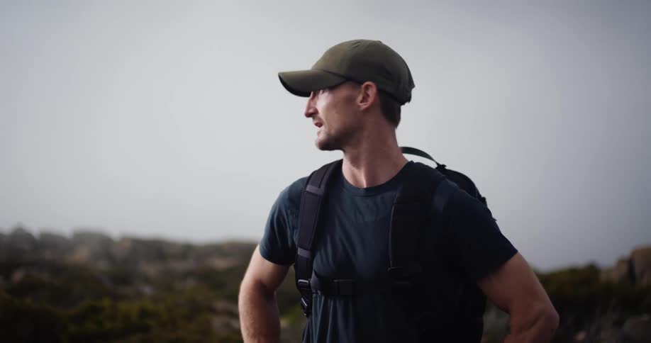 A man is outdoors and is hiking during the daytime