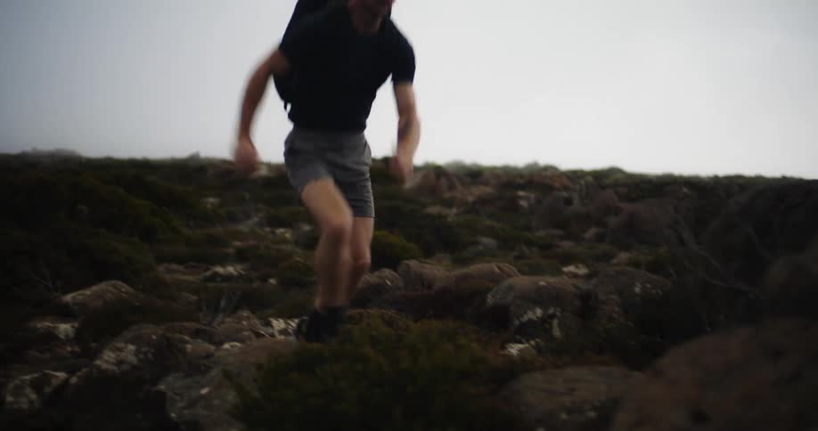 A man is jogging outdoors through a wilderness area