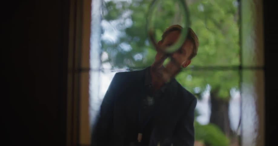 A salesman knocks on the door of a home and peeks through the window