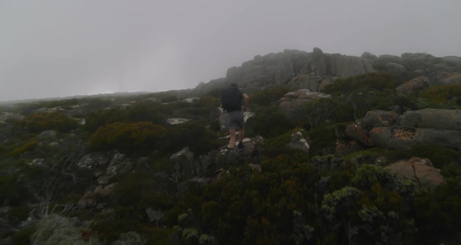 A man runs up the side of a canyon