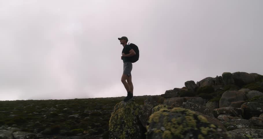 A man is hiking through a mountainous area