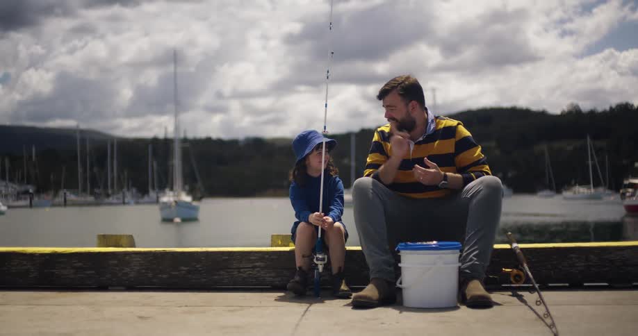 A father and daughter talk while fishing