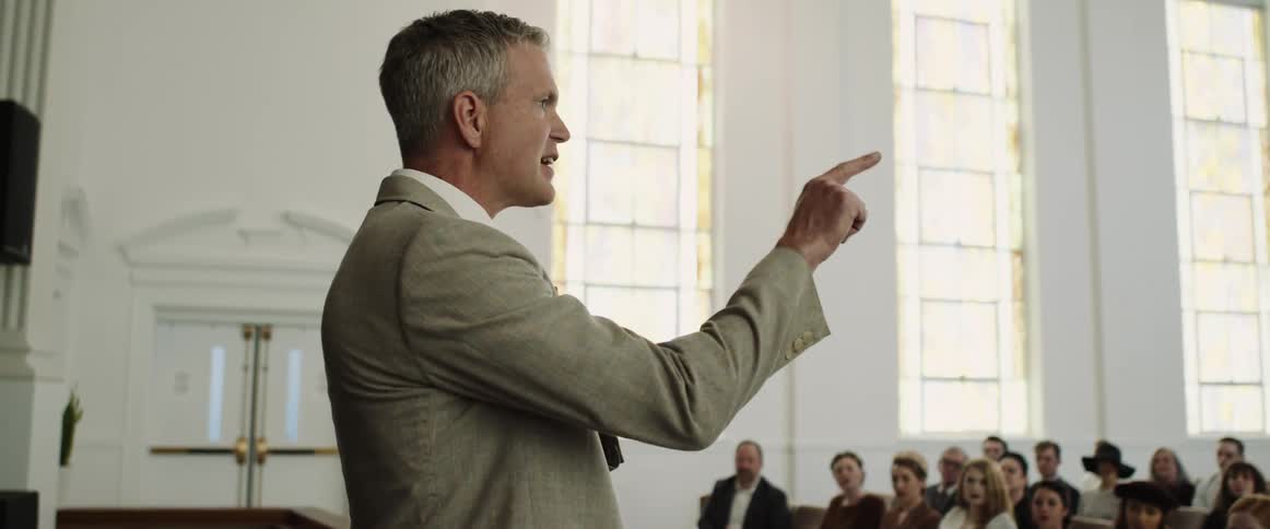 A pastor gives a sermon to a packed church