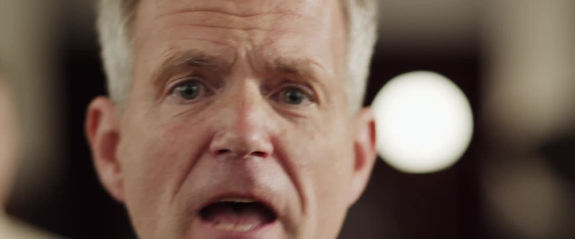 A man is yelling and looks angry in a building