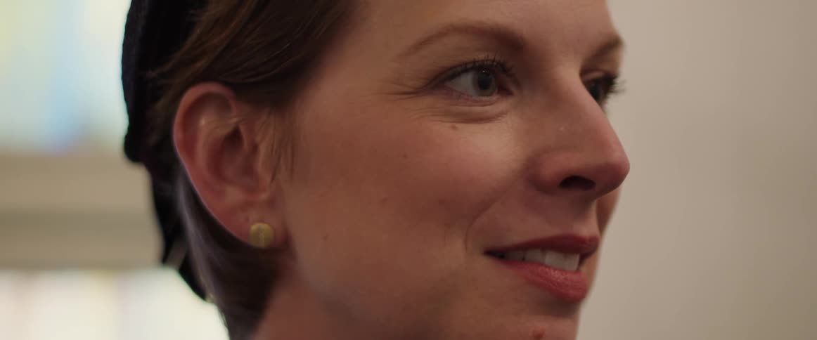 Woman talks then scrunches up her nose while she smiles