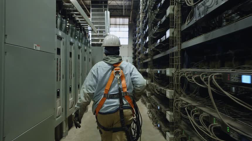 A person walks through a building with server equipment