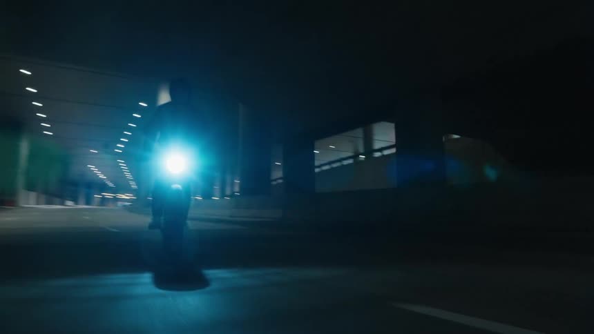 A person is driving a motorcycle during the night time
