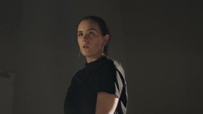 A woman is dancing by herself in a room