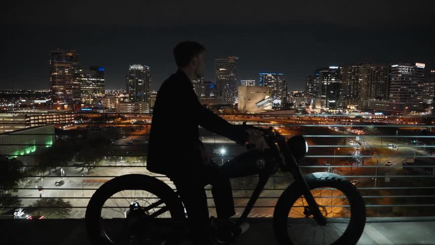 A man is riding a bike in a downtown city