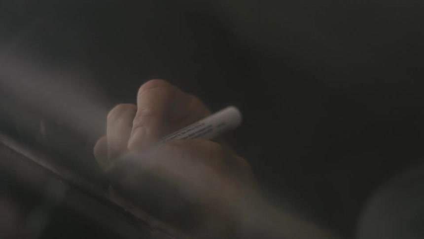 A person is writing with a marker