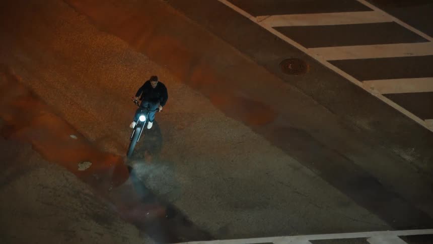 Man riding motorcycle turns corner at intersection then drives past waiting car