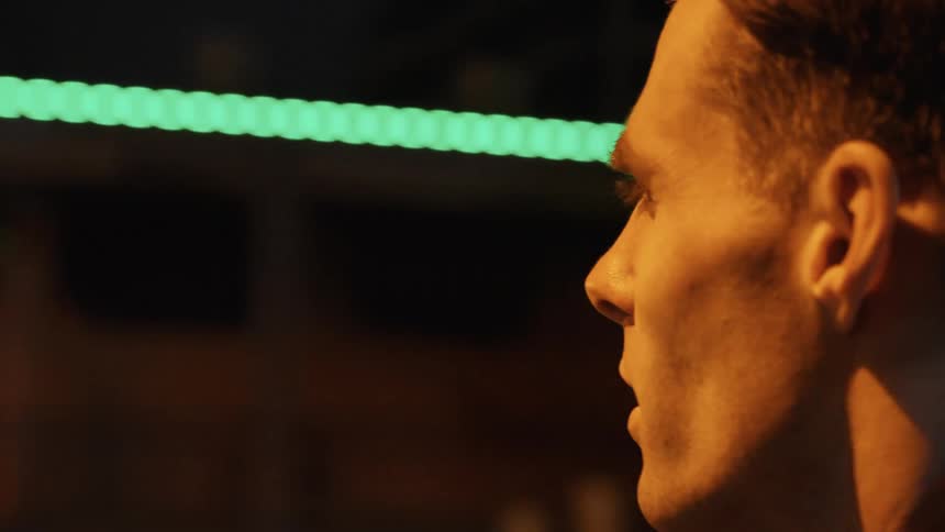 An up close of a mans face who is moving fast down a street