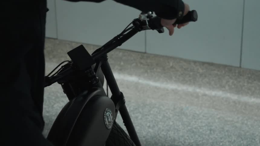 A person dressed in black getting onto a black motorcycle