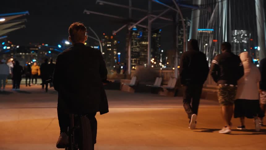 Pedestrians are walking through a city at night