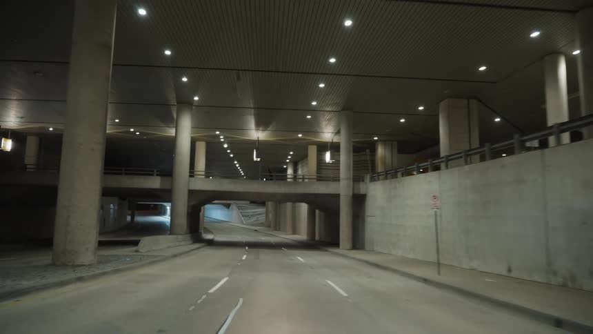 Person crosses bridge over road moving through structure