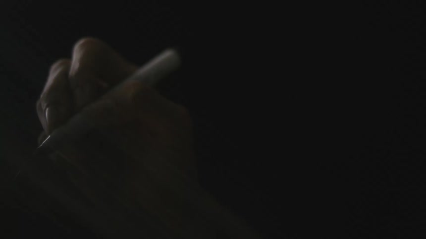 Close up view of a person using a pen is displayed