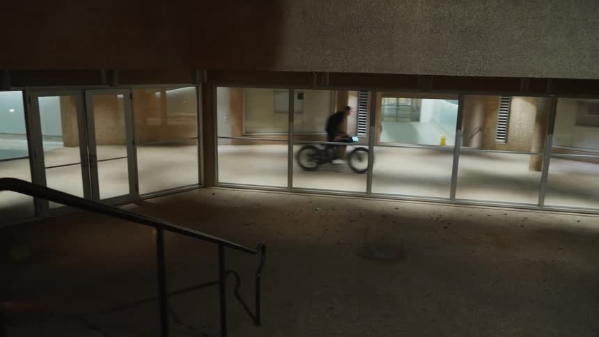 A young man is riding his bike outdoors at night time