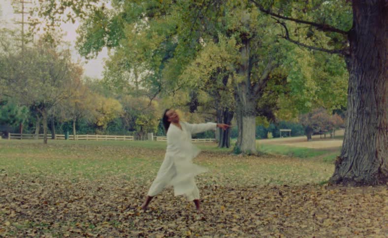 A young man is dancing in the forest around the day time
