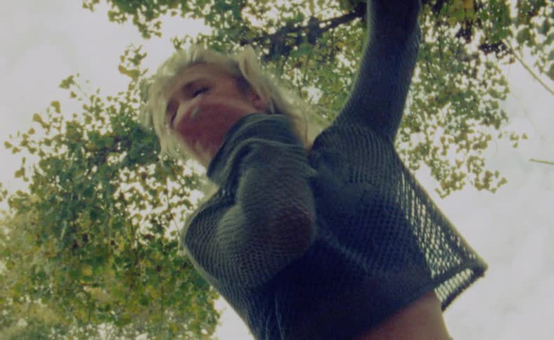 A woman is dancing outdoors during the spring time
