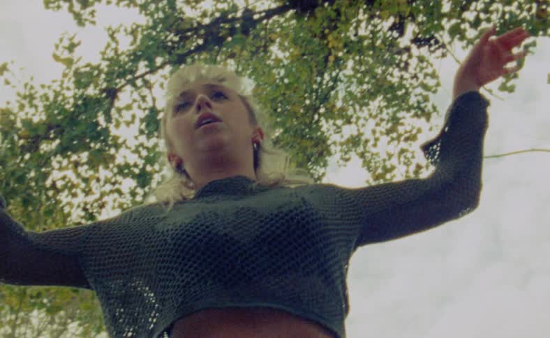 A woman is dancing outdoors during the spring time