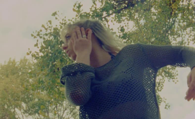 A woman is dancing by herself outdoors