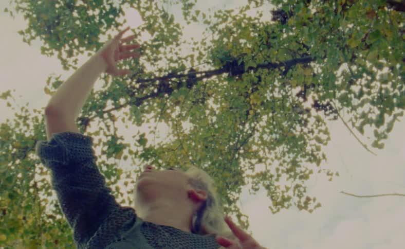 A woman is dancing outdoors during the spring time