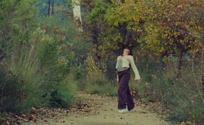 A young woman is dancing around the nature area
