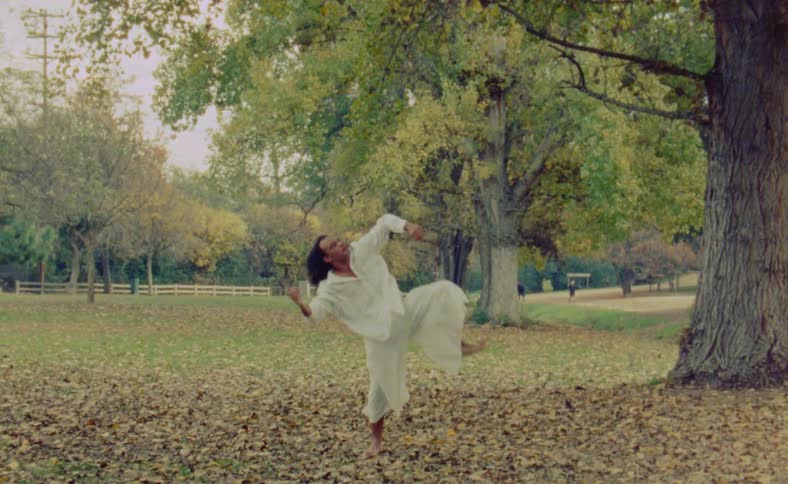 A man is dancing by himself in an open field