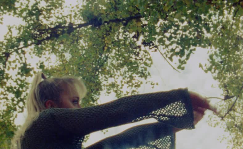 A young woman is dancing outdoors around the nature area