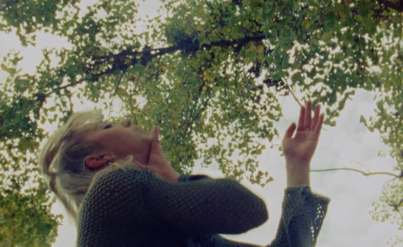 A woman is dancing outdoors during the spring time