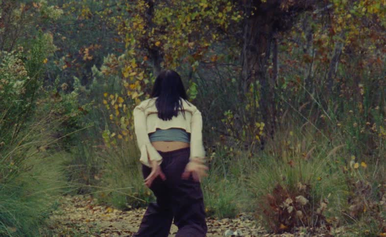A young woman is dancing outdoors in the day time