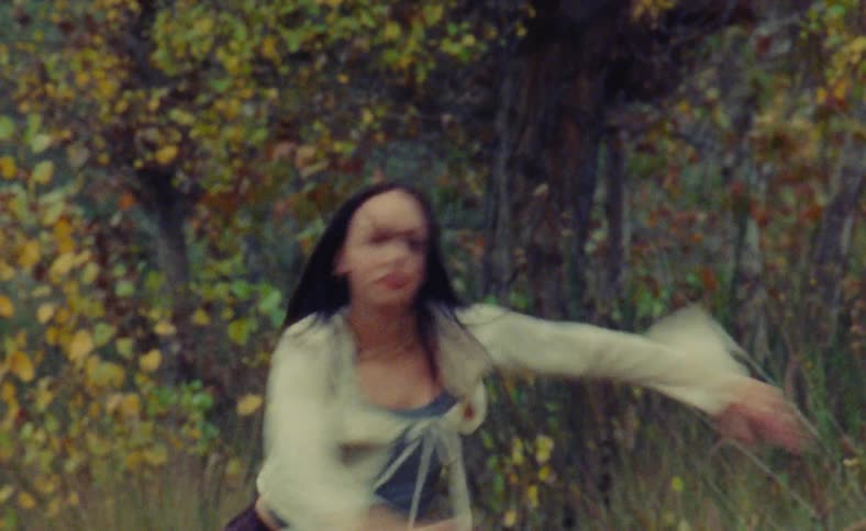 A young woman is dancing outside in the nature area