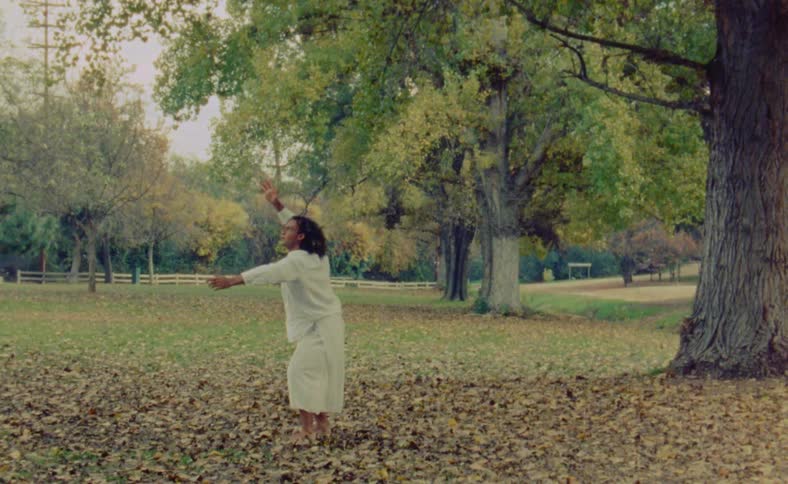 A man is dancing outdoors during the daytime