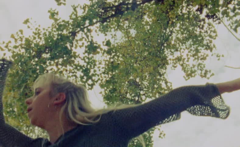 A woman is dancing outdoors during the spring time