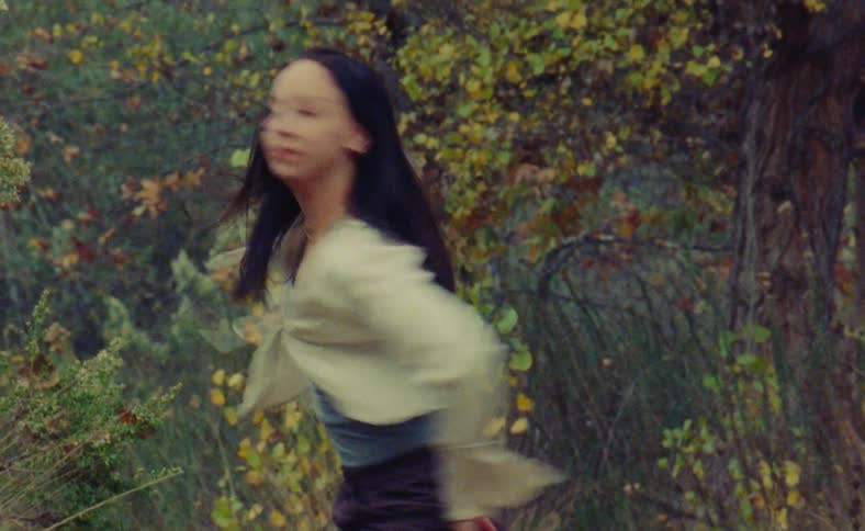 A woman is dancing outdoors during the autumn season