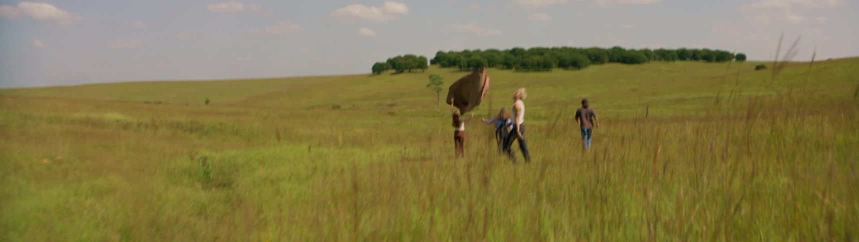 The view is of friends playing around the nature area in the day time
